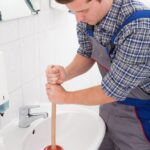 plumber unclogging sink