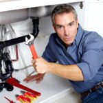 plumber fixing the kitchen sink pipes
