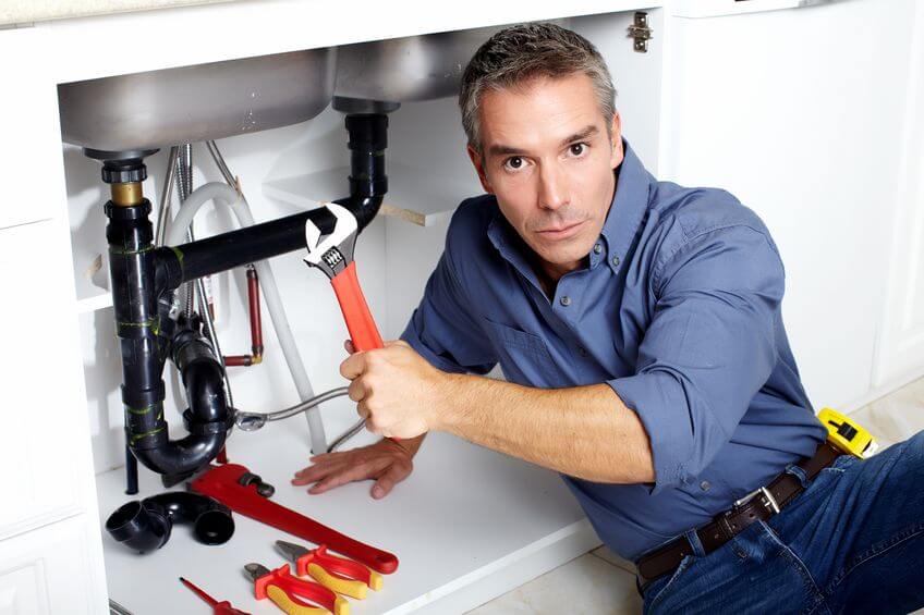 plumber fixing the kitchen sink pipes