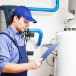 plumber holding inspection sheet list by water heater