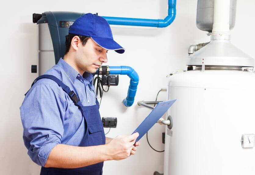 plumber holding inspection sheet list by water heater