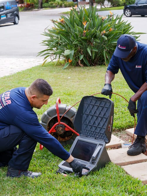 plumbers doing a sewer drain video inspection outside 