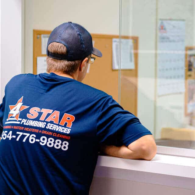 4 star plumbing services plumber standing in office