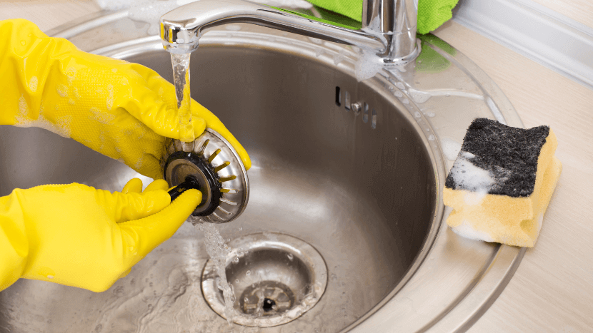 person cleaning drain filter