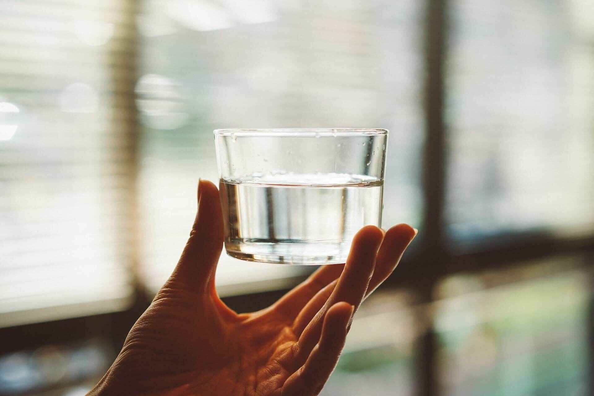 person holding glass of water